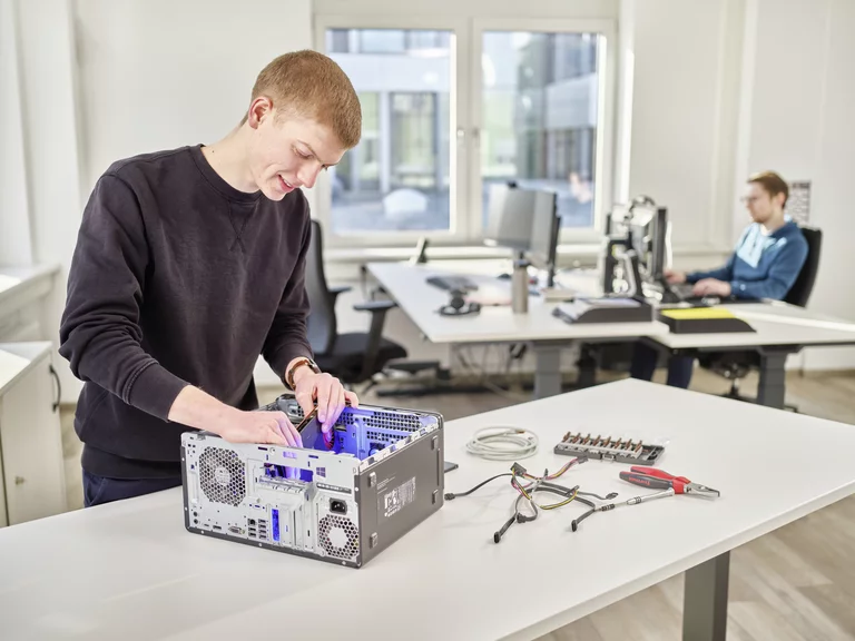 Auszubildender zum Fachinformatiker bei Bette arbeitet an der Hardware eines Computers in einem modernen Büro.