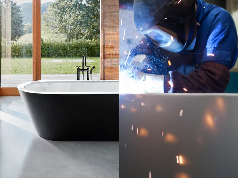 BetteStarlet Oval Silhouette Badewanne und Bette Produktion Freistehende Badewanne BetteStarlet Oval Silhouette vor Panoramafenster, daneben Schweißer bei der Herstellung mit Funkenflug.