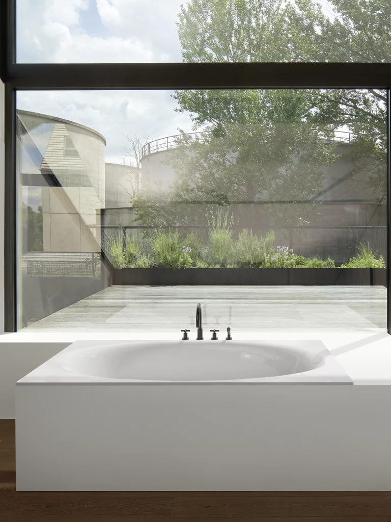 BetteEve: Einbaubadewanne auf einem Holzfußboden vor einer Fensterfront. 