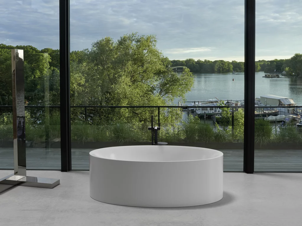 BetteEve Oval Silhouette: овальная, отдельно стоящая ванна с видом на озеро через большие стеклянные окна.
