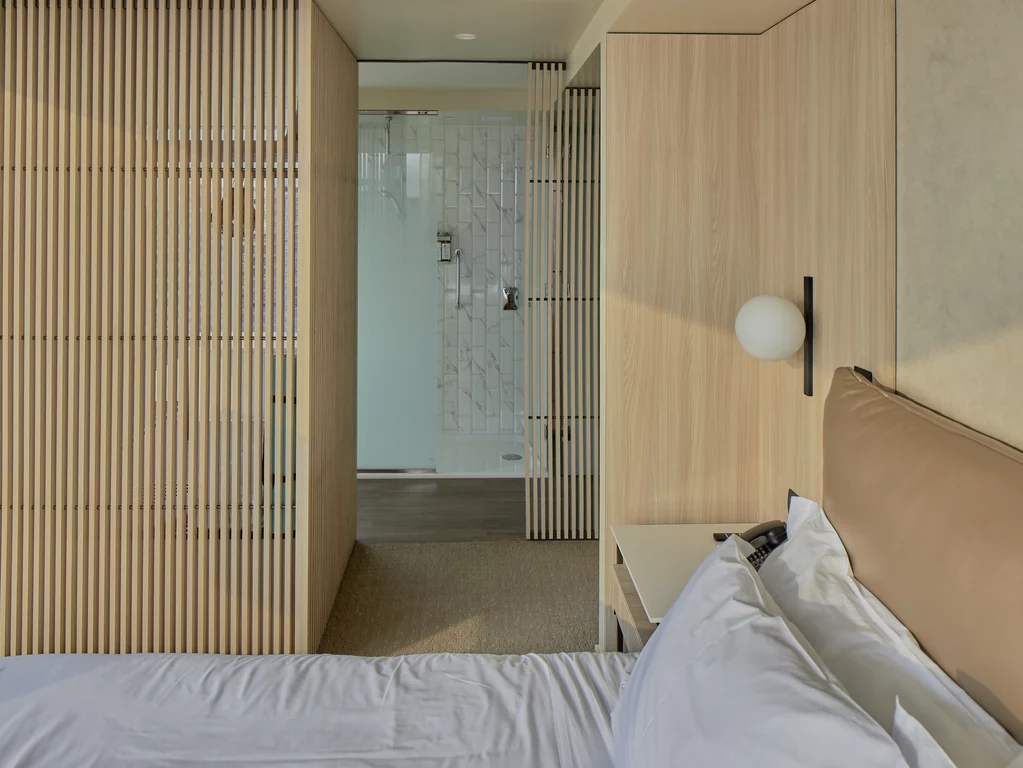 Chambre à coucher avec des matériaux naturels à l'hôtel Iberostar de Lima. En accord avec son ambition écologique, les espaces de l'Iberostar Selection ont été conçus avec des matériaux naturels comme le bois, le verre et la pierre.
