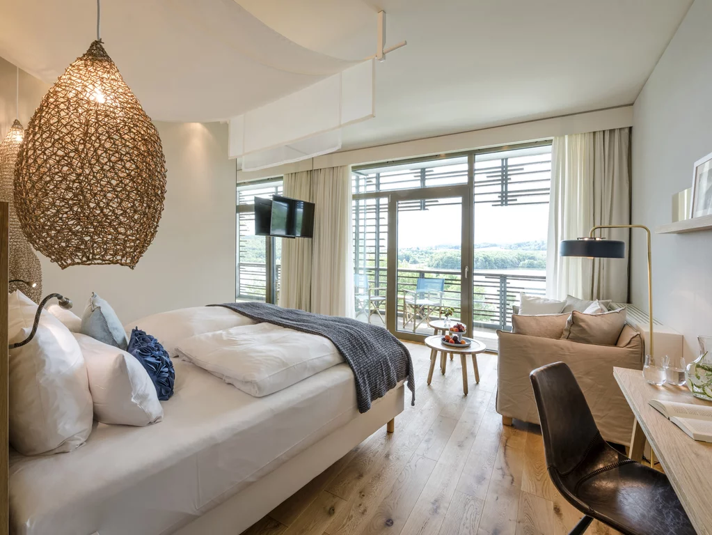 Schlafzimmer mit Blick auf die Weite des Bostalsees in der Seezeitlodge, Hotel & Spa, Nohfelde, Saarland. Das behagliche Schlafzimmer mit Blick auf die Weite des Bostalsees in der Seezeitlodge, Hotel & Spa, Nohfelde, im Saarland.