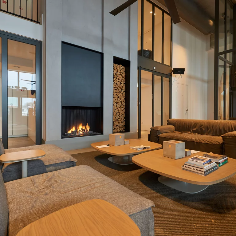 De gezellige en elegante loungeruimte met open haard in Strandhotel Cadzand, Nederland. Strandhotel Cadzand, Nederland, biedt precies die luxe momenten die een vakantie aan zee bijzonder ontspannend maken - bij de open haard, bijvoorbeeld.