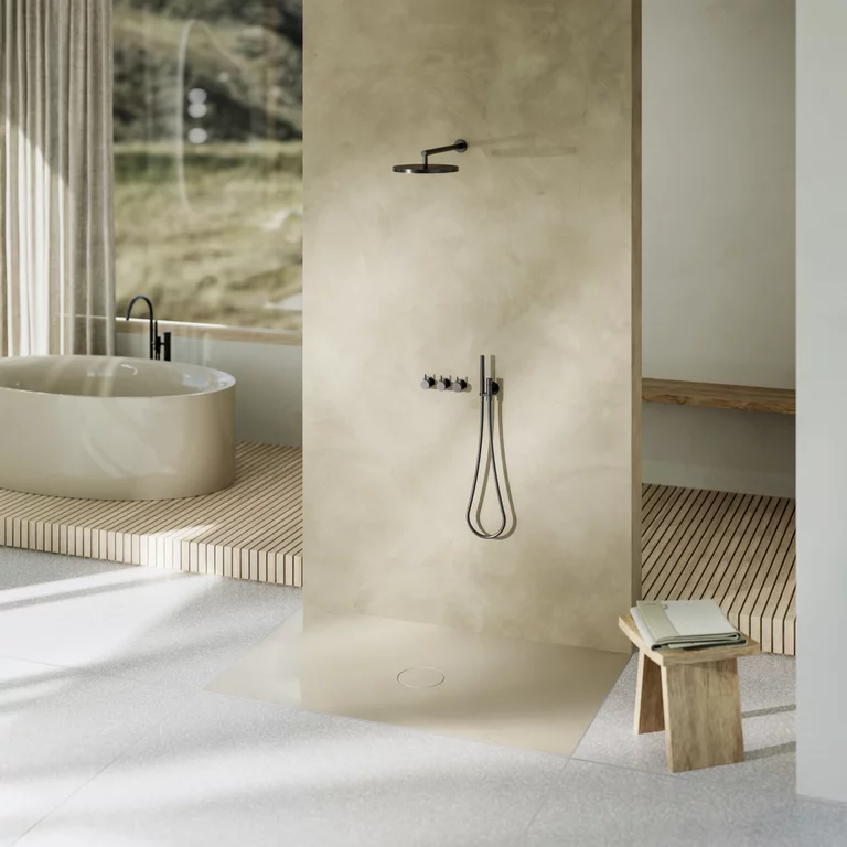 Open douche met beige wand en vlakke douchevloer, vrijstaand bad op houten platform met uitzicht naar buiten.