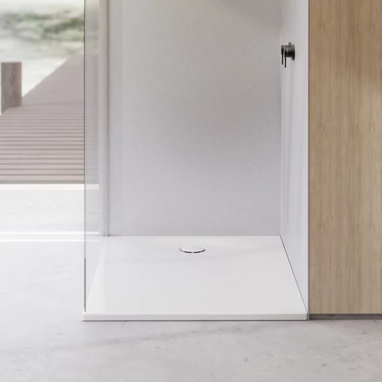 Minimalistische douche met witte, vlakke douchevloer, glazen wand en wandbekleding in lichte houtlook.