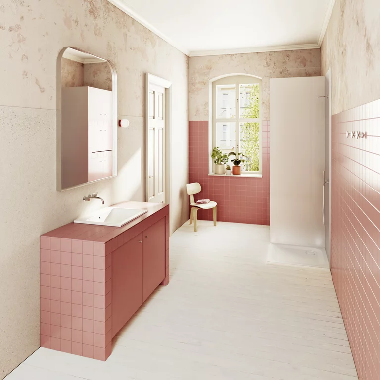Helles Bad mit rosa Fliesen, Waschtisch und bodengleicher Dusche, Tageslicht durch Fenster mit Pflanzen auf der Fensterbank.