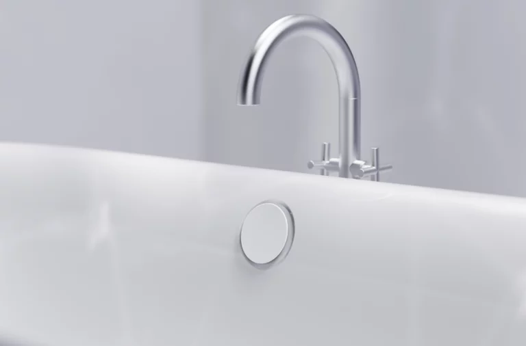Weiße Badewanne mit rundem Überlauf und gebogener Armatur vor hellgrauem Hintergrund.