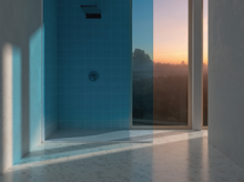 Rectangular steel enamel shower tray in modern glass shower with blue wall tiles.