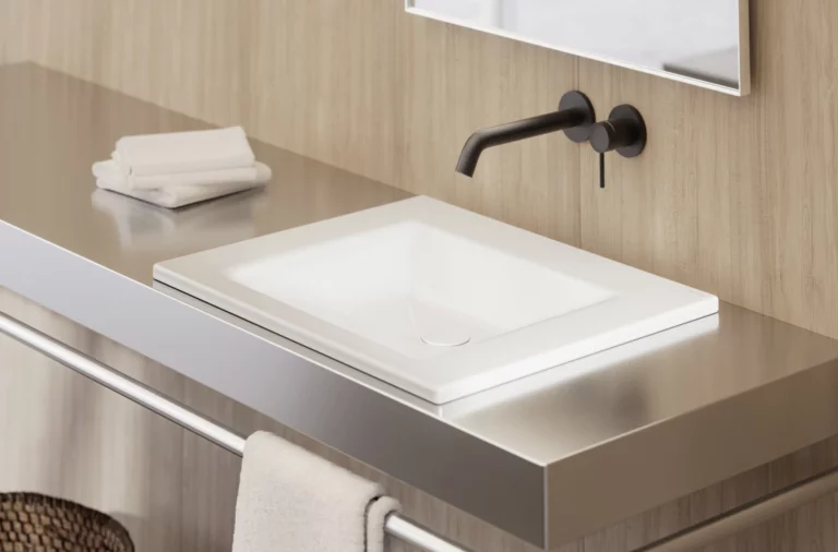 Современная квадратная раковина белого цвета на металлической консоли с чёрным настенным смесителем и полотенцами.