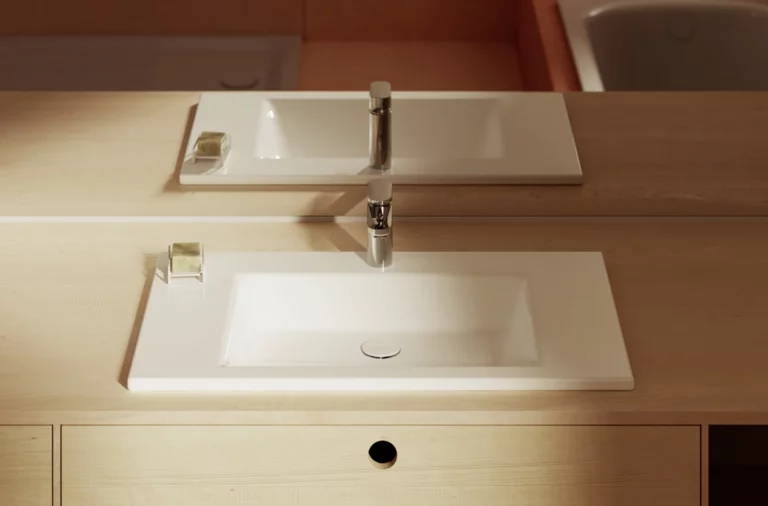 Прямоугольная белая раковина на светлой деревянной столешнице с зеркалом, мыльницей и современным смесителем.