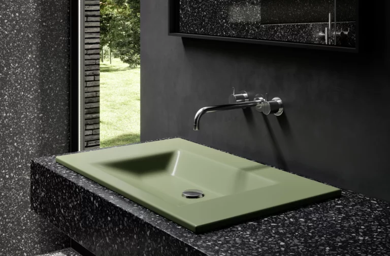 Зелёная прямоугольная стальная эмалированная раковина на чёрной столешнице, настенный смеситель, современная ванная с окном.