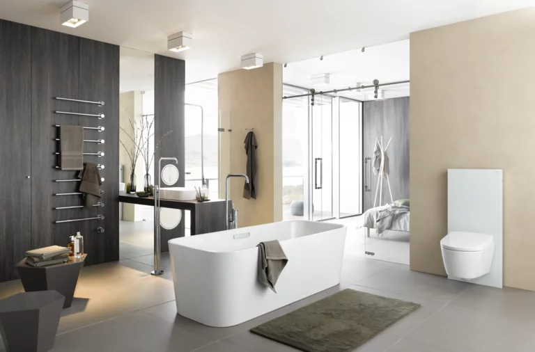 Freistehende, rechteckige Badewanne aus Stahl-Email in modernem Badezimmer mit Einbauplatte und wandhängendem WC.