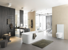 Отдельностоящая прямоугольная ванна из стальной эмали в современной ванной с встроенной панелью и подвесным унитазом.