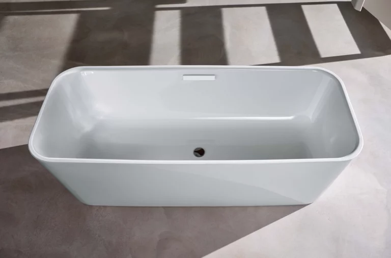 Freistehende, rechteckige Badewanne aus Stahl-Email mit abgerundeten Ecken auf hellem Boden.