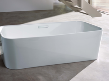 Freistehende Badewanne aus Stahl-Email, rechteckige Form, abgerundete Ecken, auf grauem Boden in modernem Raum.