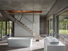 Отдельностоящая прямоугольная стальная эмалированная ванна и две прямоугольные раковины на встроенной панели в современной ванной.