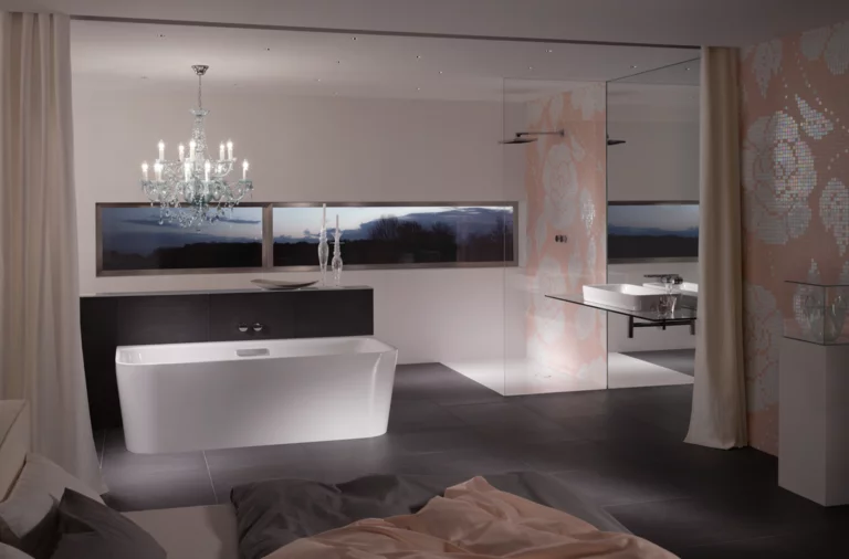 Freestanding rectangular steel-enamel bathtub, washbasin on countertop beside it, modern bathroom with large shower.