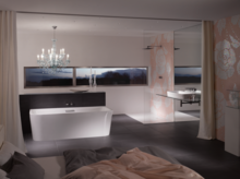 Freestanding rectangular steel-enamel bathtub, washbasin on countertop beside it, modern bathroom with large shower.