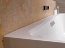 Rectangular steel-enamel bathtub with smooth edges, installed in front of patterned wall.