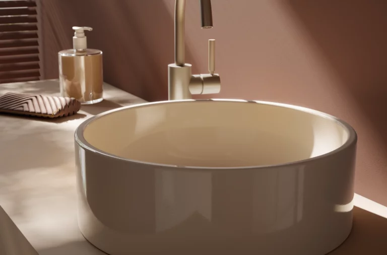 Lavabo redondo de acero esmaltado sobre encimera, junto a dispensador de jabón y toalla, grifería moderna.