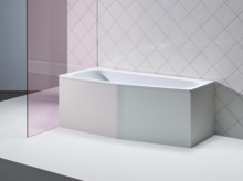 Rechteckige Badewanne aus Stahl-Email vor weiß gefliester Wand, umgeben von moderner, klarer Umgebung.