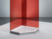 Fünfeckige Duschwanne aus Stahl-Email in weiß, mit roter Glasabtrennung, in modernem Badezimmer, barrierefrei zugänglich.