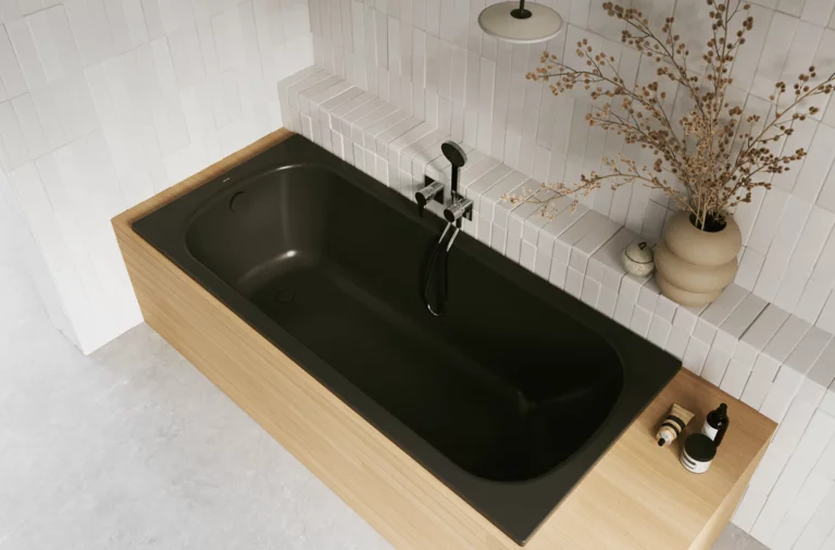 Aufsicht auf helles Bad mit rechteckiger Badewanne, dunkler Innenfläche, beiger Einfassung, Armatur und Vase.