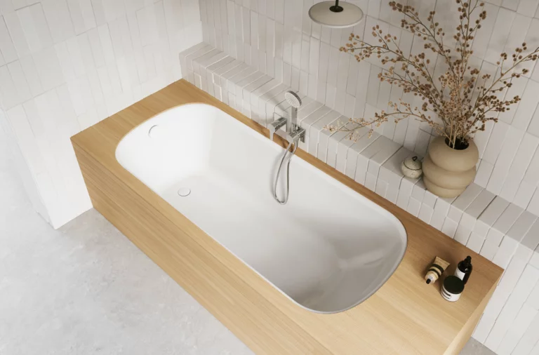 Aufsicht auf helles Bad mit eingelassener Badewanne, weißer Innenfläche, beiger Einfassung, Armatur und Vase.