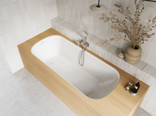 Aufsicht auf helles Bad mit eingelassener Badewanne, weißer Innenfläche, beiger Einfassung, Armatur und Vase.
