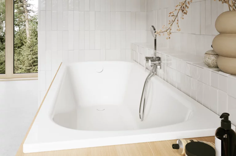 Helles Bad mit eingelassener weißer Badewanne, Fenster, Wandarmatur, Handbrause, Ablage und Pflegeprodukten.