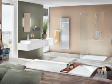 Large rectangular steel enamel bathtub, rectangular steel enamel shower tray, rectangular washbasin on countertop in modern bathroom.