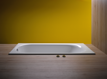Rectangular steel enamel bathtub, flat inset into wood-look floor, in front of yellow wall.