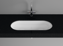 Oval steel enamel washbasin in white, flush-mounted in black countertop, modern faucet above.