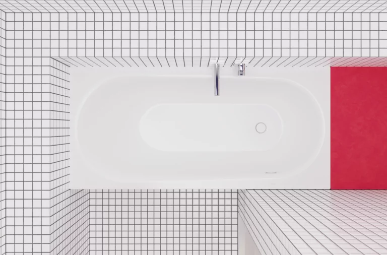 Weiße, eingebaute Badewanne in einem Raum mit kleinkarierten weißen Fliesen und rotem Ablagebereich am Kopfende.