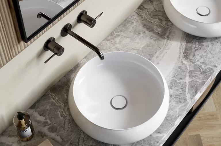 Deux vasques rondes sur plan en marbre gris, robinets muraux, miroirs et sol en bois clair.