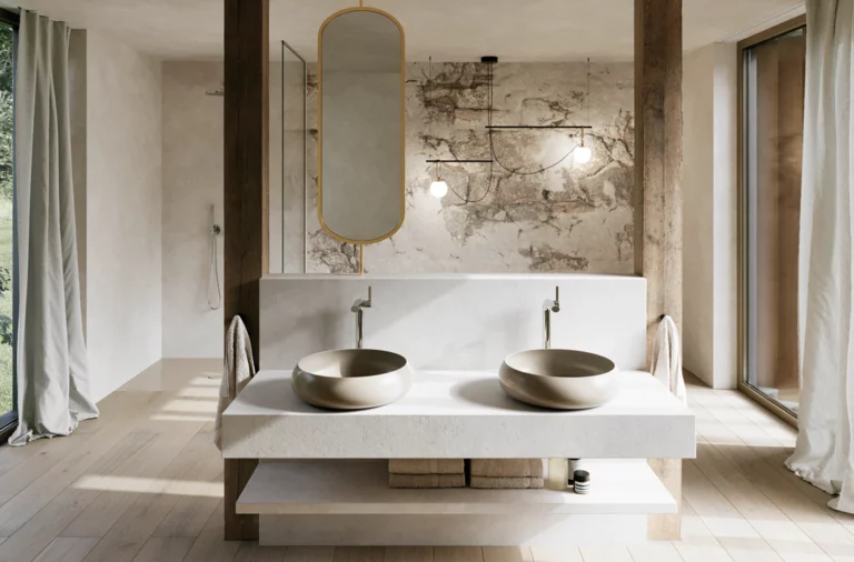 Modernes Badezimmer mit zwei beigen Waschtischen auf breiter weißer Konsole, ovalem Spiegel und Wand in Natursteinoptik.
