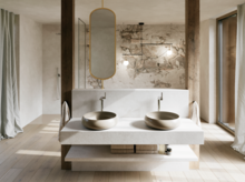 Modernes Badezimmer mit zwei beigen Waschtischen auf breiter weißer Konsole, ovalem Spiegel und Wand in Natursteinoptik.