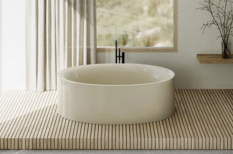 Freistehende, ovale Badewanne in hellem Beige auf Holzpodest vor Fenster mit Vorhang und schlichter Wanddekoration.