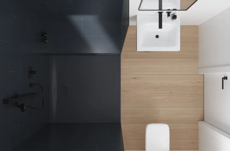 Quadratisches Stahl-Email-Waschbecken auf Einbauplatte, daneben WC, barrierefreie Dusche mit dunklen Fliesen und bodengleicher Fläche.