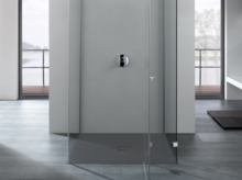 Plato de ducha rectangular de acero vitrificado a nivel del suelo, rodeado de paredes de vidrio, diseño moderno de baño.