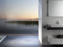 Plato de ducha rectangular de acero esmaltado junto a lavabo rectangular sobre encimera en baño moderno.