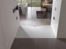 Прямоугольный душевой поддон из стальной эмали, вровень с полом, с центральным сливом в современной ванной.