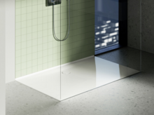 Белый душевой поддон с стеклянной перегородкой, зелёной плиткой и видом на город через окно в пол.