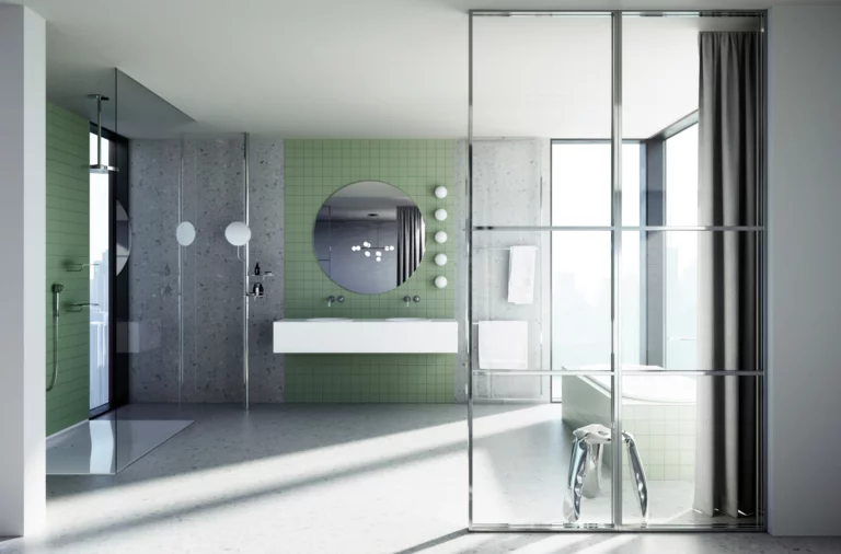 Modernes Badezimmer mit grün gefliester Dusche, Doppelwaschtisch, rundem Spiegel und viel Tageslicht durch große Fenster.