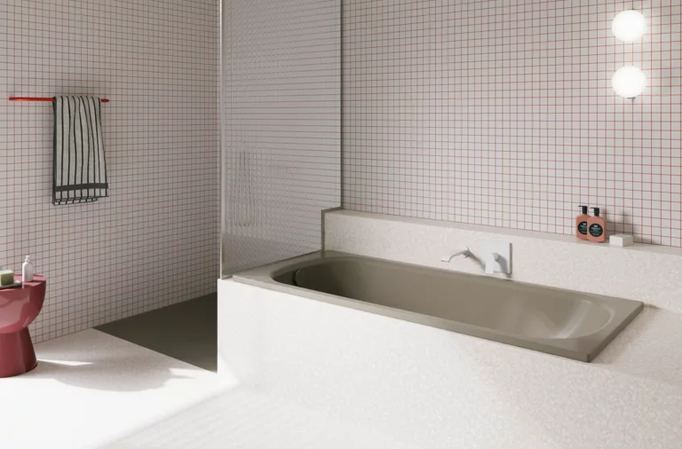 Bañera gris beige de acero titanio esmaltado en baño luminoso con azulejos blancos y ducha abierta.