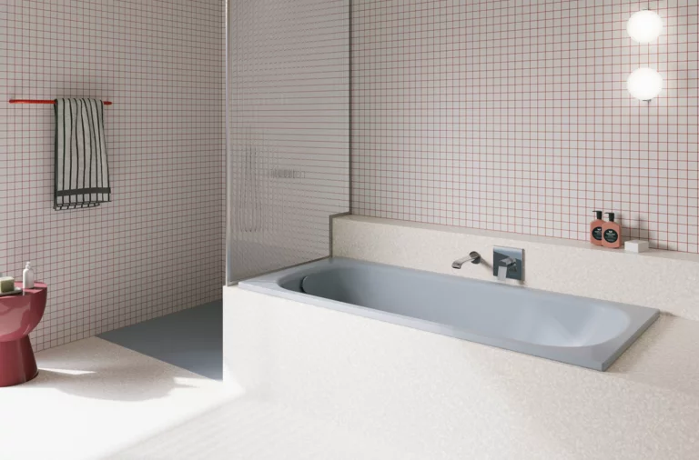 Bañera azul claro de acero titanio esmaltado en baño luminoso con azulejos blancos y ducha abierta.