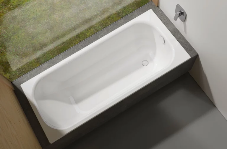 Rechteckige Badewanne aus Stahl-Email, eingebaut in eine Umrandung, Blick von oben, modernes Badezimmer.