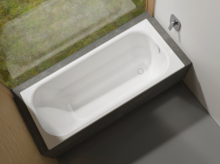 Rechteckige Badewanne aus Stahl-Email, eingebaut in eine Umrandung, Blick von oben, modernes Badezimmer.