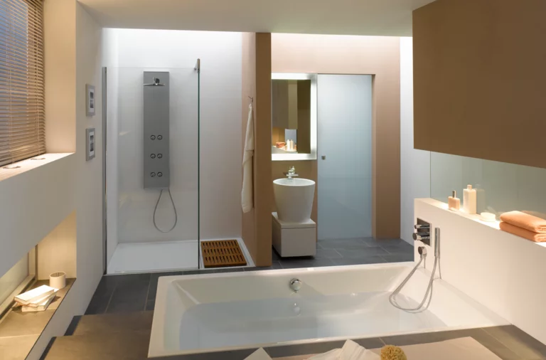 Rechteckige Badewanne und Duschwanne aus Stahl-Email, separates rundes Waschbecken, modernes, helles Badezimmer mit klaren Linien.