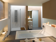 Rechthoekig bad en douchebak van staal-email, apart rond wastafel, modern, licht badkamer met strakke lijnen.